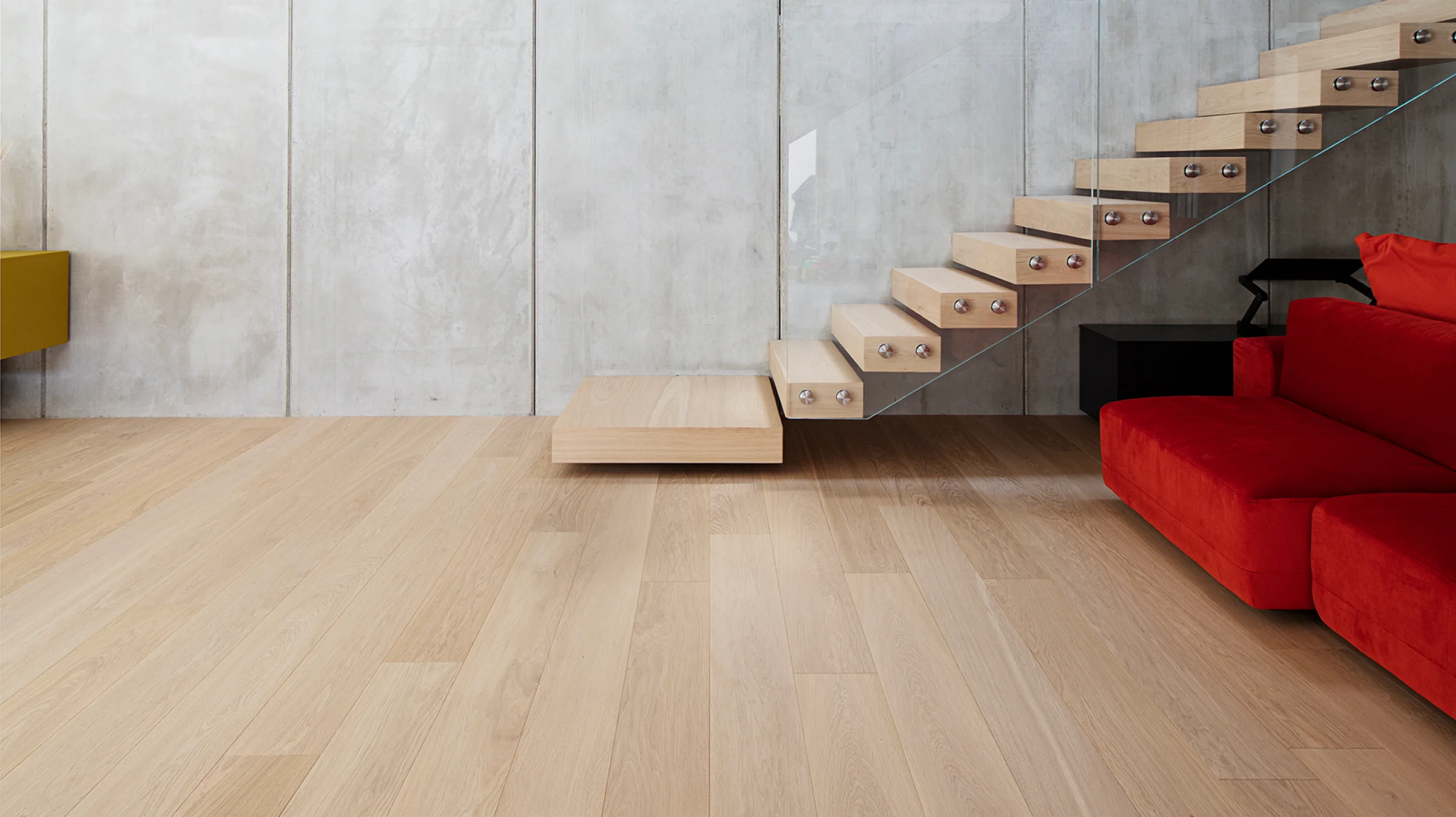 Ambiente con scala in legno e divano rosso